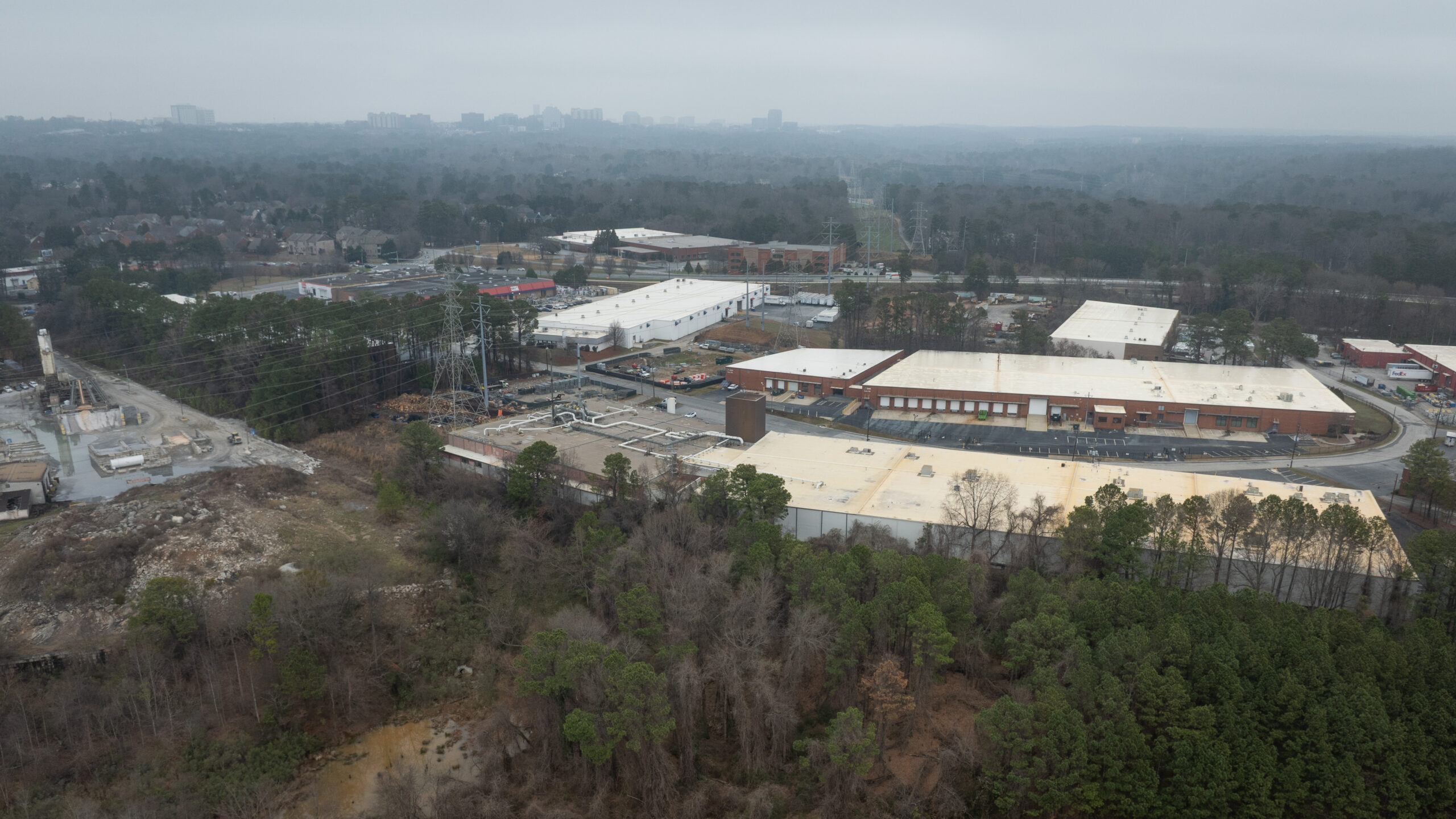 An aerial view of large industrial buildings in a flat suburban landscape