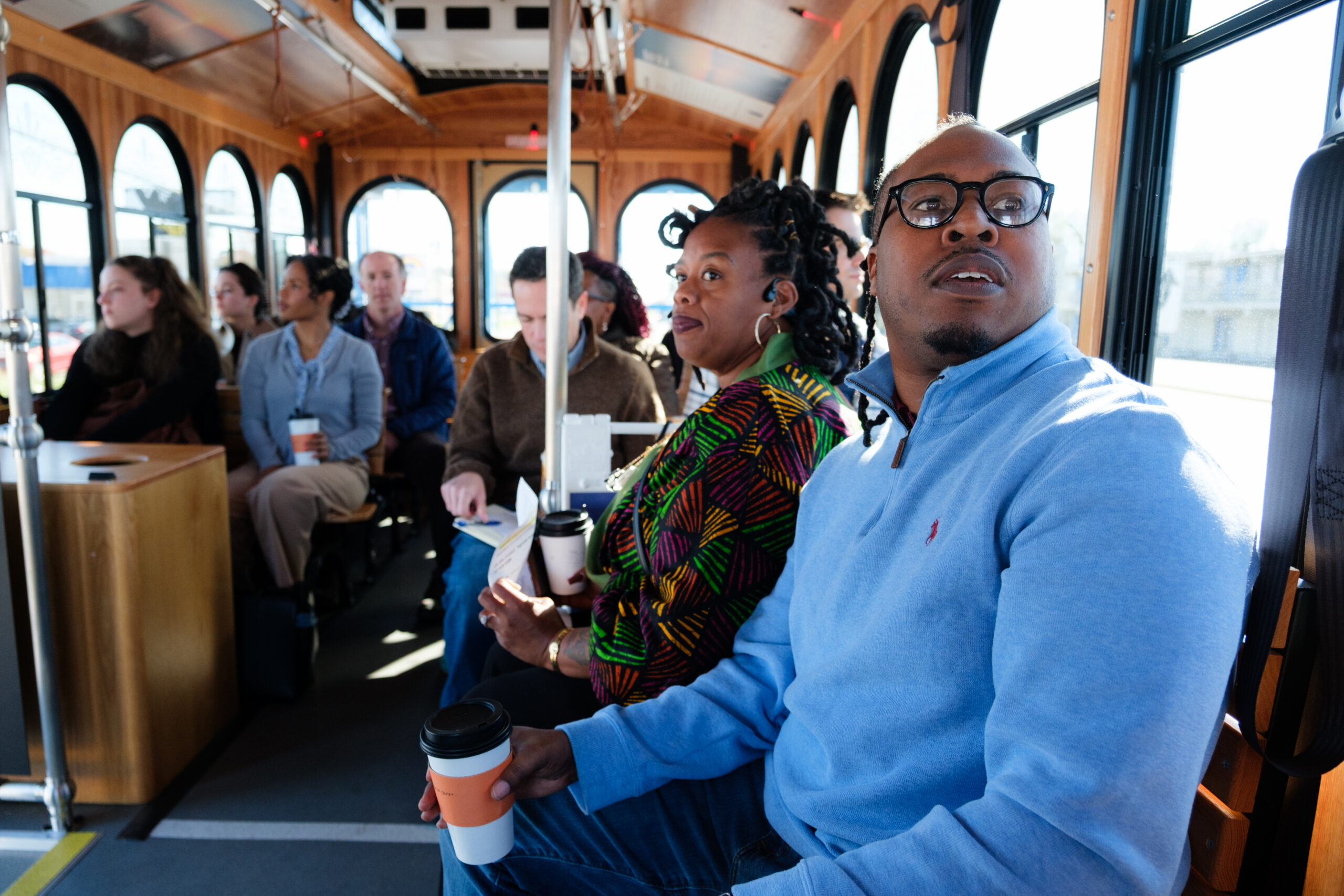 A group of professionals rides a trolley to tour the neighborhood.